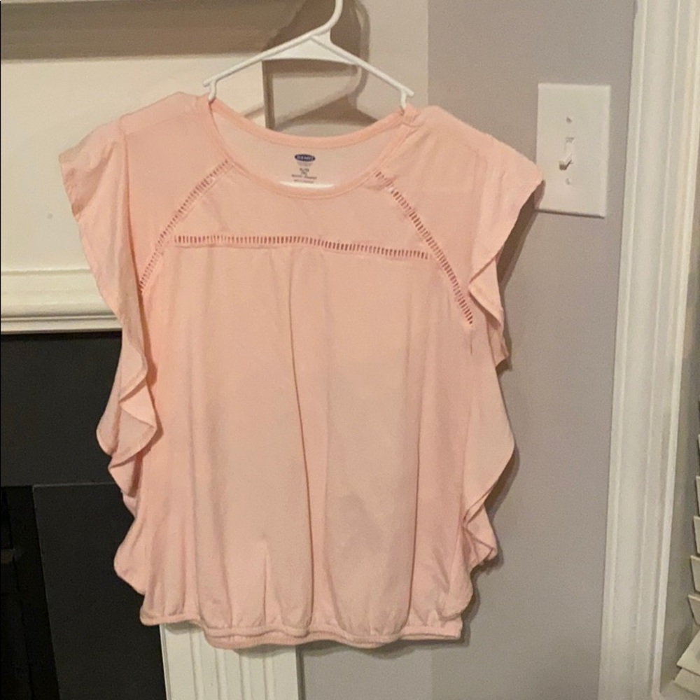 Pink shirt with ruffles on the side.